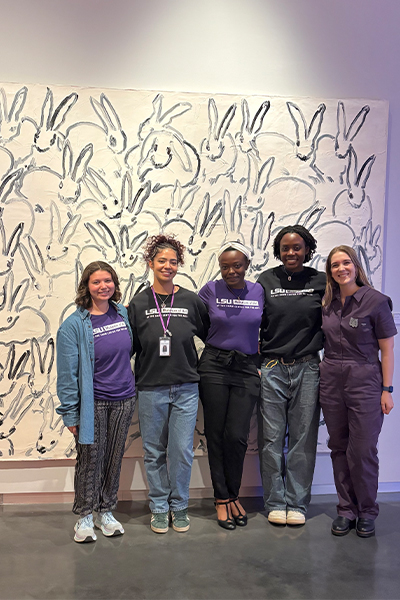 veterinary student with LSU students in LSU Museum of Art standing in front of large painting of rabbits
